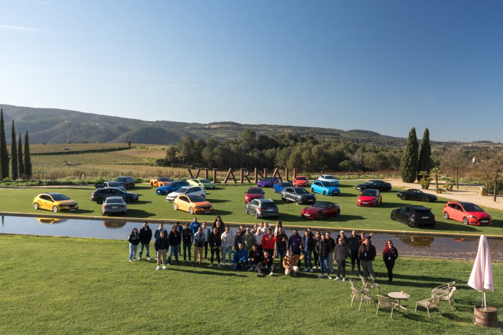 Miembros de Dream & Drive posan ante sus coches aparcados en Vilarnau, entre viñedos