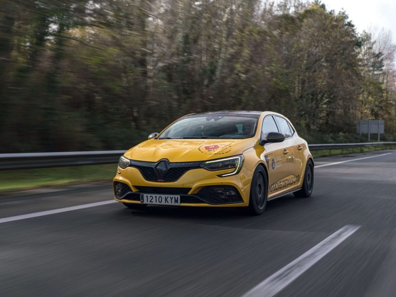 Renault Mégane RS amarillo circulando por una autovía entre árboles