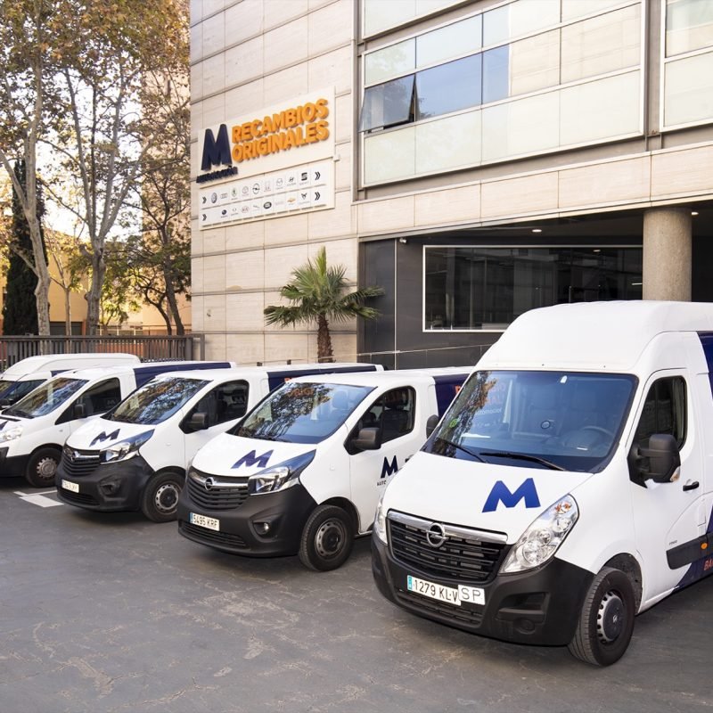 Furgonetas de reparto de M Automoción Recambios Originales aparcadas frente a su sede